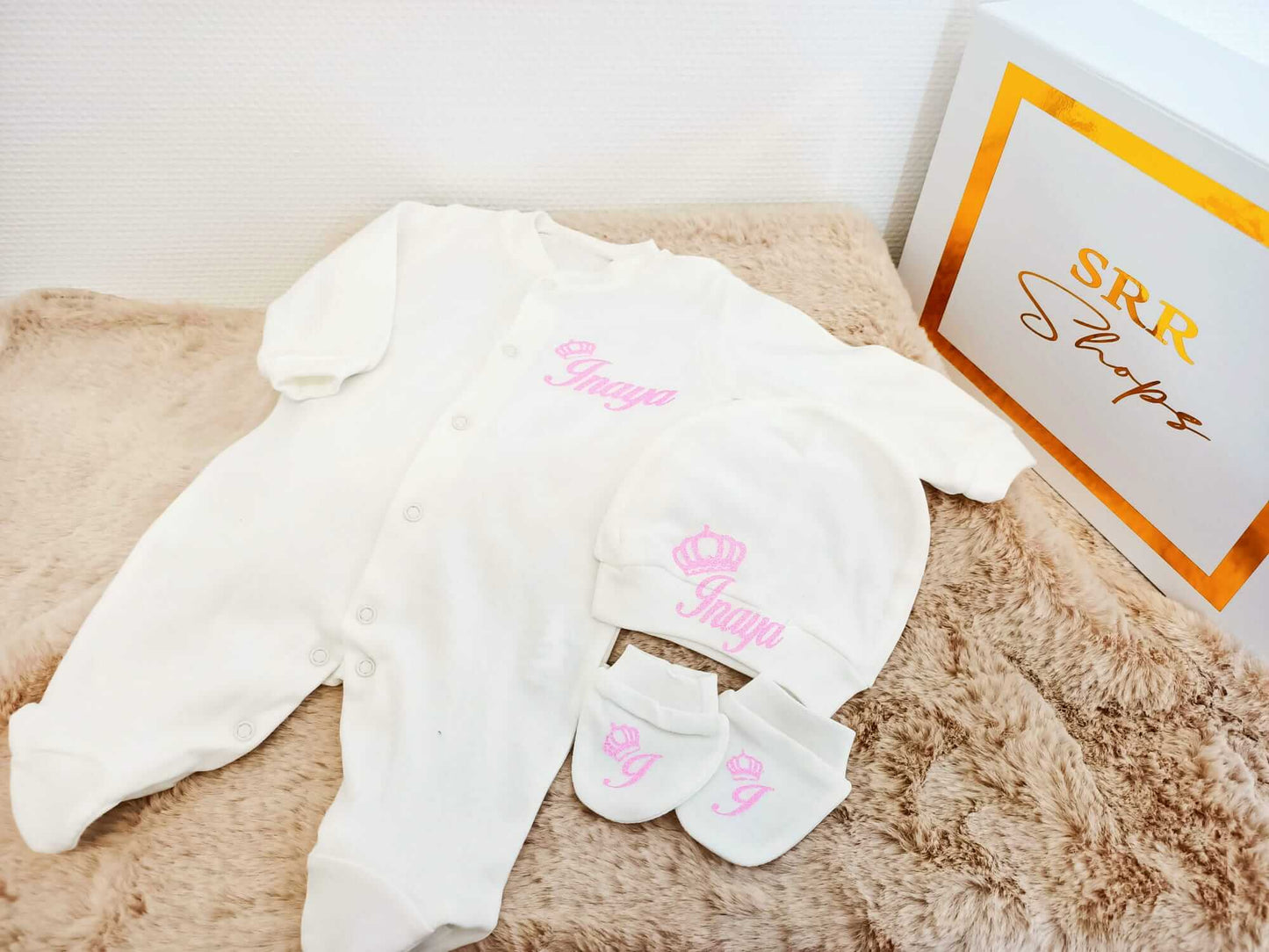 Pyjamas bébé personnalisés blancs avec bonnet et chaussons sur une couverture douce, ensemble mignon pour nuits tendres