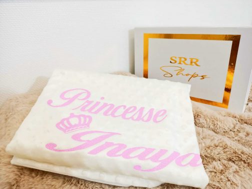 Couverture bébé personnalisée blanche avec le texte "Princesse Inaya" en rose, accessoire essentiel pour chaleur et douceur.